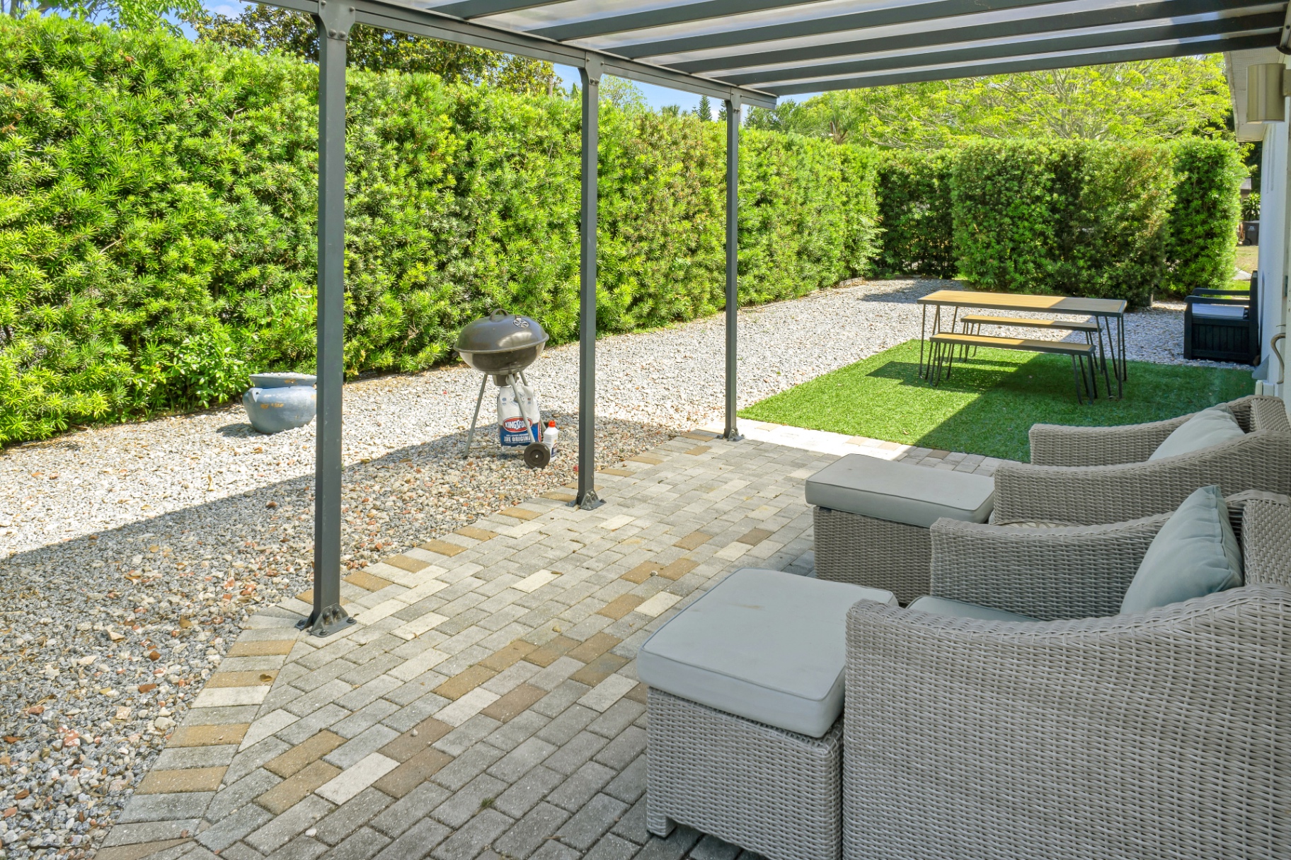 Covered outdoor patio seating and grill area at The Garden at Ibis