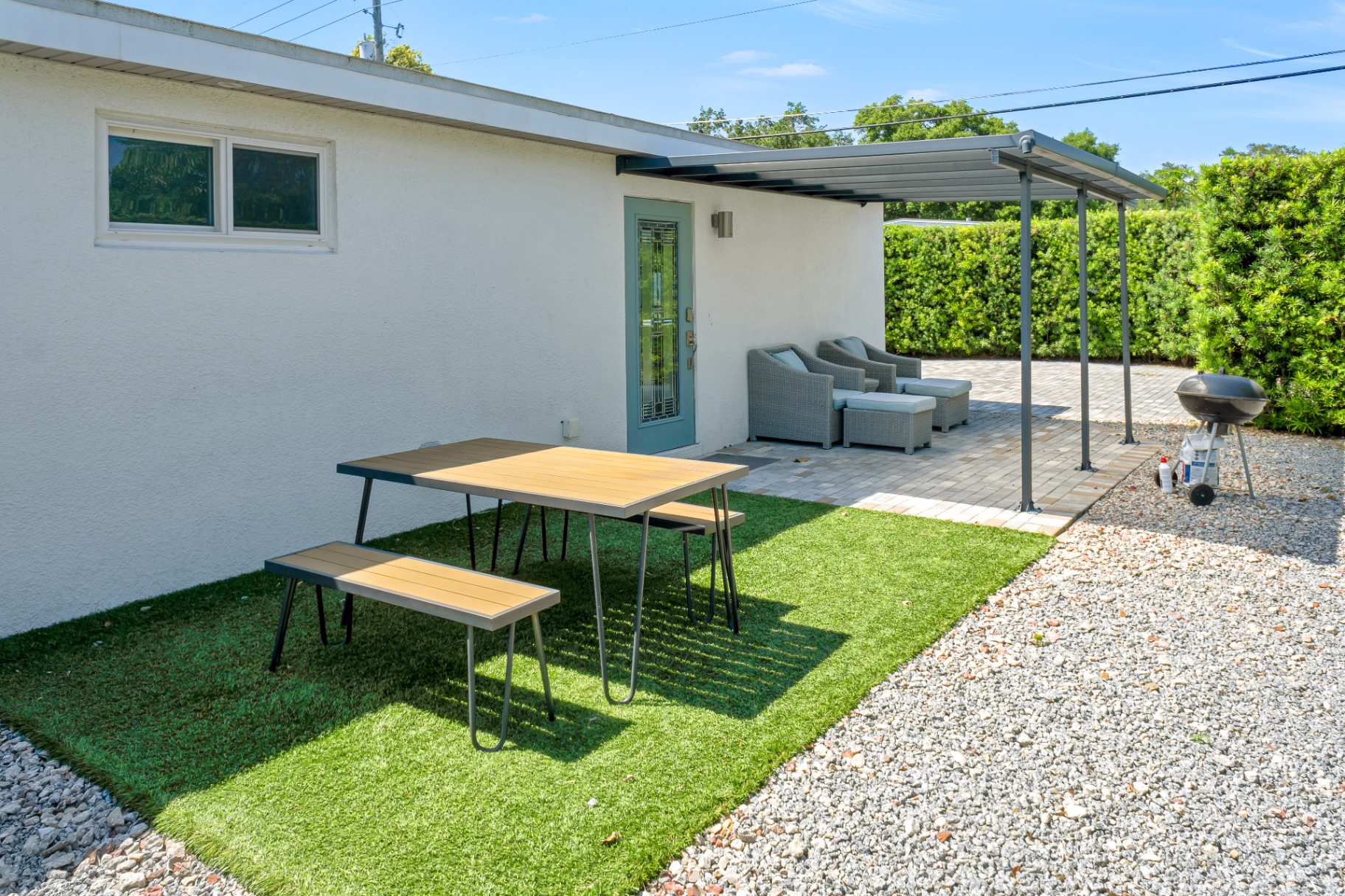 Outdoor dining table on the turf patio at The Garden at Ibis